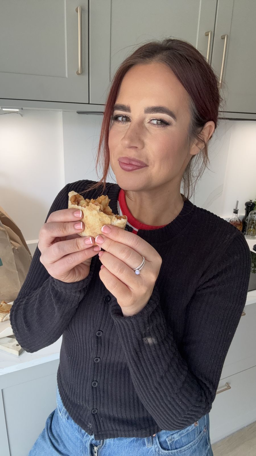 Hayley Dean taking a bite in her kitchen